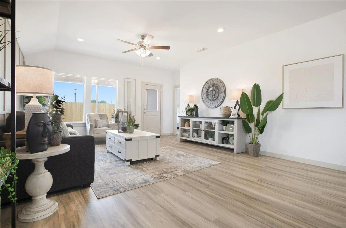 7415 8th Street Lubbock, TX 79416 - Photo 14 of 22 a living room with furniture a wooden floor and a chandelier