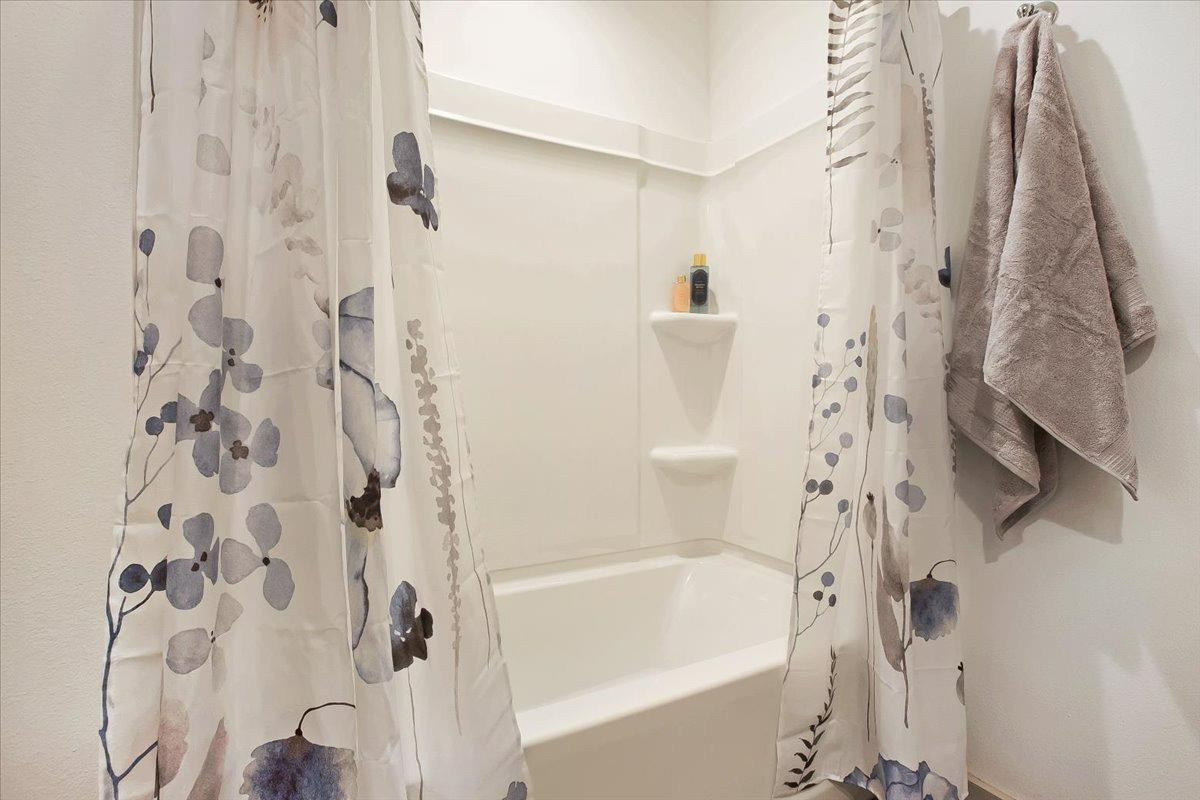 7415 8th Street Lubbock, TX 79416 - Photo 7 of 22 a bathroom with a bathtub and shower