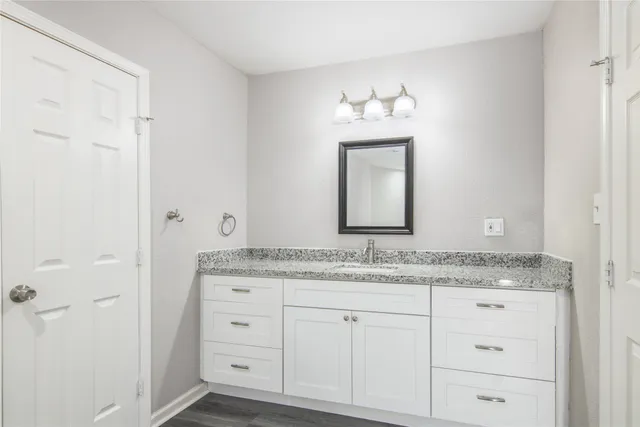 a bathroom with a granite countertop sink and a mirror