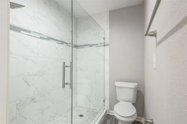 a white toilet sitting next to a shower