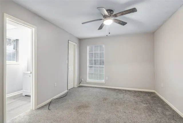 an empty room with closet and ceiling fan