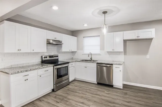 a kitchen with a sink stove and white cabinets