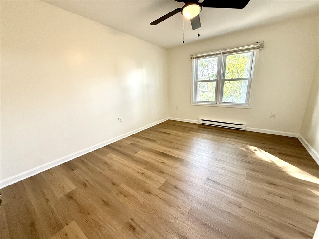 9 Olga Avenue, Unit 9 Worcester, MA 01605 - Photo 14 of 23 an empty room with wooden floor chandelier fan and windows