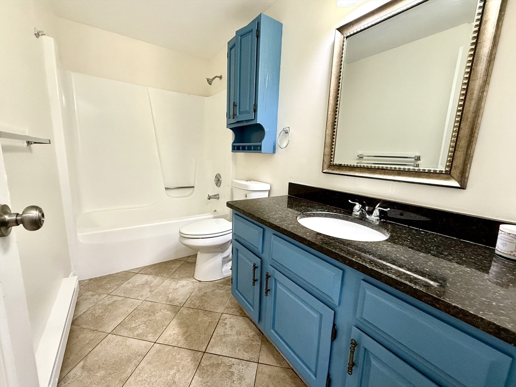 9 Olga Avenue, Unit 9 Worcester, MA 01605 - Photo 18 of 23 a bathroom with a granite countertop sink and a mirror
