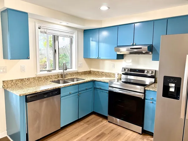a kitchen with granite countertop wooden cabinets and a stove top oven