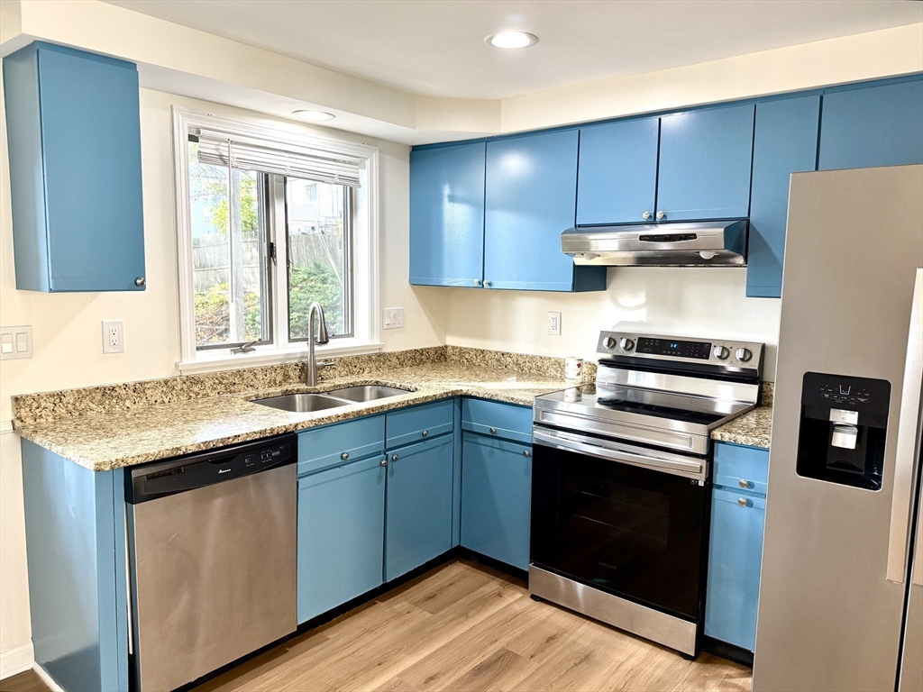 9 Olga Avenue, Unit 9 Worcester, MA 01605 - Photo 4 of 23 a kitchen with granite countertop wooden cabinets and a stove top oven