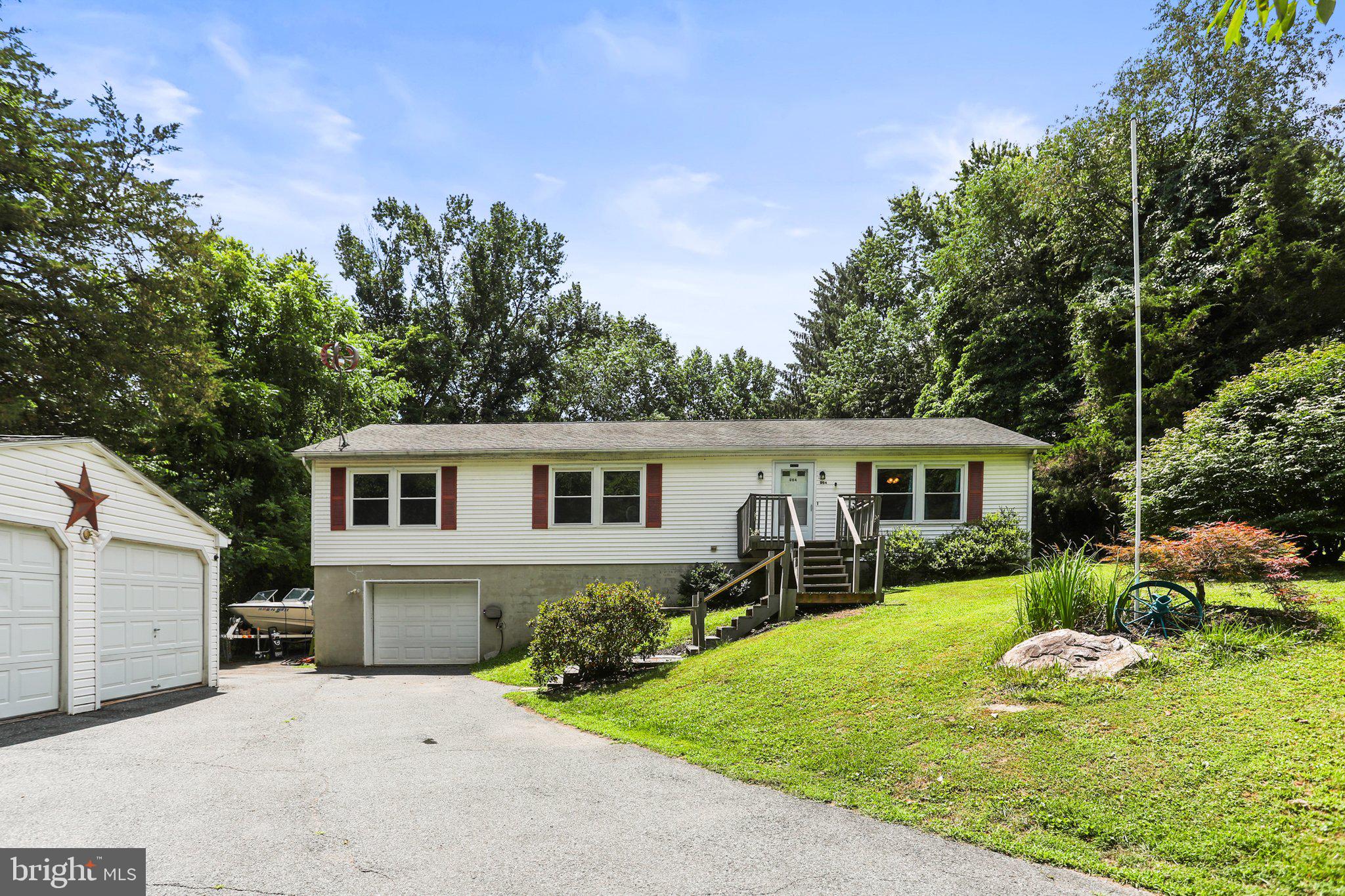 a front view of a house with a yard and trees