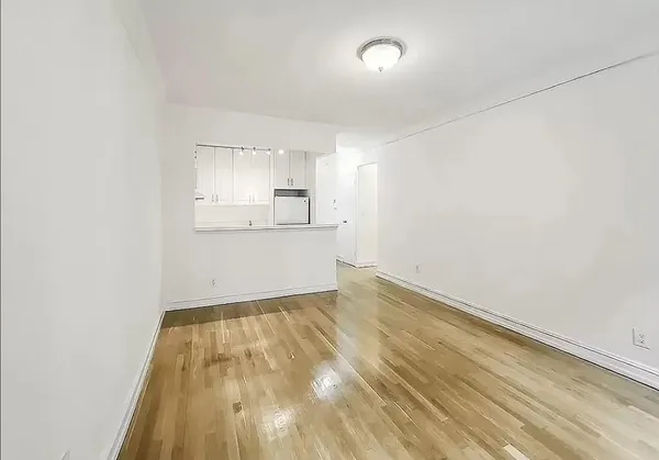 a view of a kitchen with wooden floor and cabinets