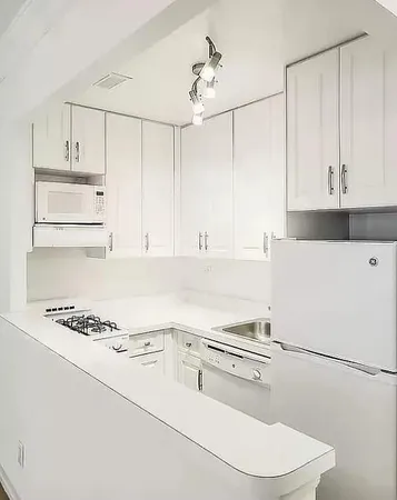a white kitchen with sink and white appliances