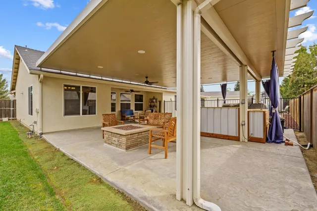 a view of a house with a yard and a large tree