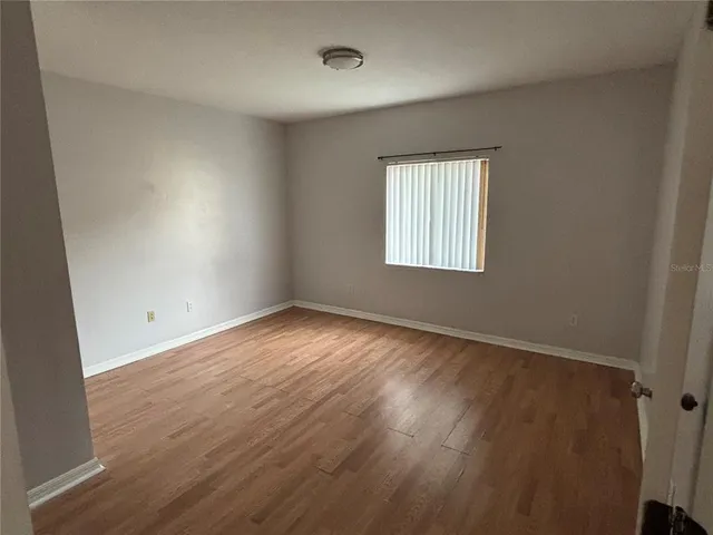 a view of empty room with wooden floor