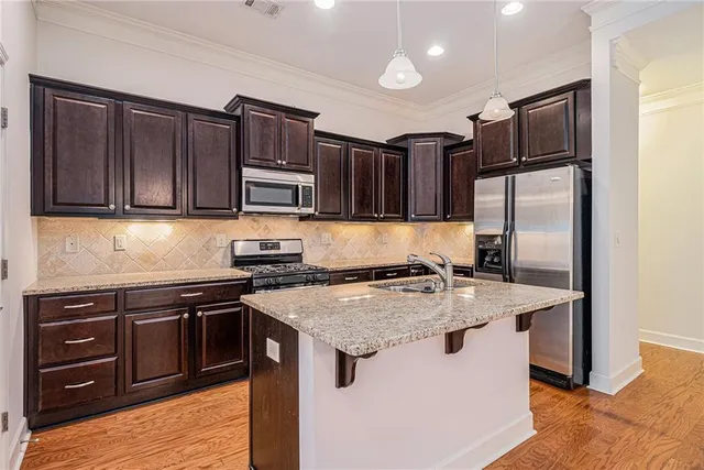 a kitchen with stainless steel appliances granite countertop a sink stove and refrigerator