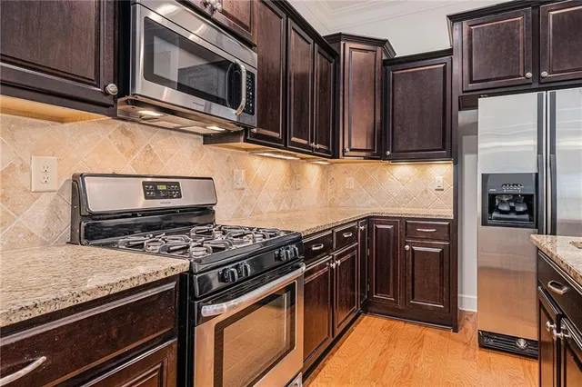 a kitchen with stainless steel appliances granite countertop a stove microwave and refrigerator