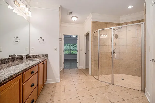 a bathroom with a granite countertop sink a mirror and shower