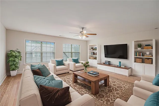 a living room with furniture a flat screen tv and a large window