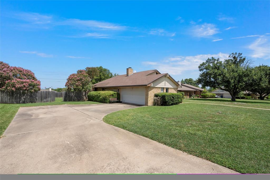 116 Boleman Drive Hewitt, TX 76643 - Photo 2 of 38 View of side of property featuring an attached garage, concrete driveway, brick siding, and a chimney