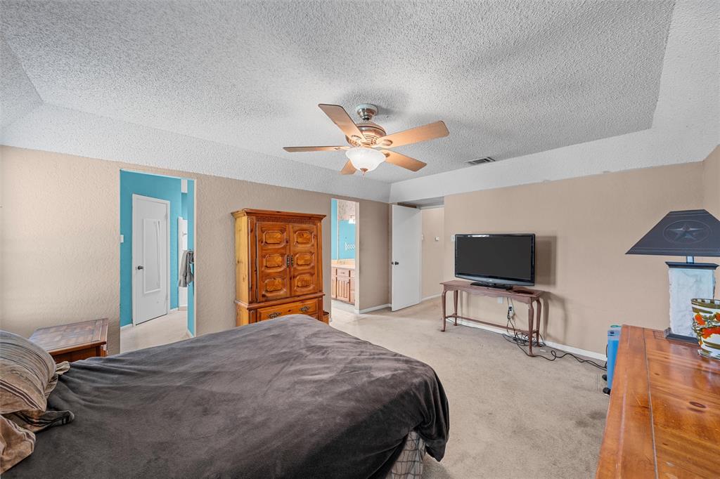 116 Boleman Drive Hewitt, TX 76643 - Photo 24 of 38 Bedroom with a textured ceiling, light colored carpet, ceiling fan, a textured wall, and connected bathroom