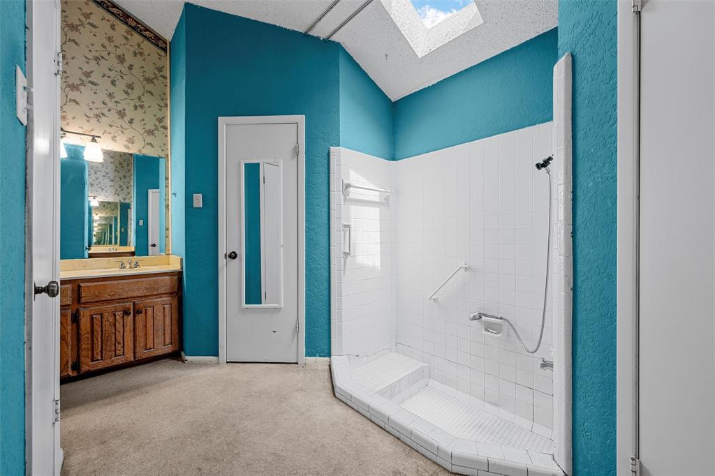 116 Boleman Drive Hewitt, TX 76643 - Photo 26 of 38 Bathroom with a skylight, a shower stall, vanity, a textured ceiling, and a textured wall