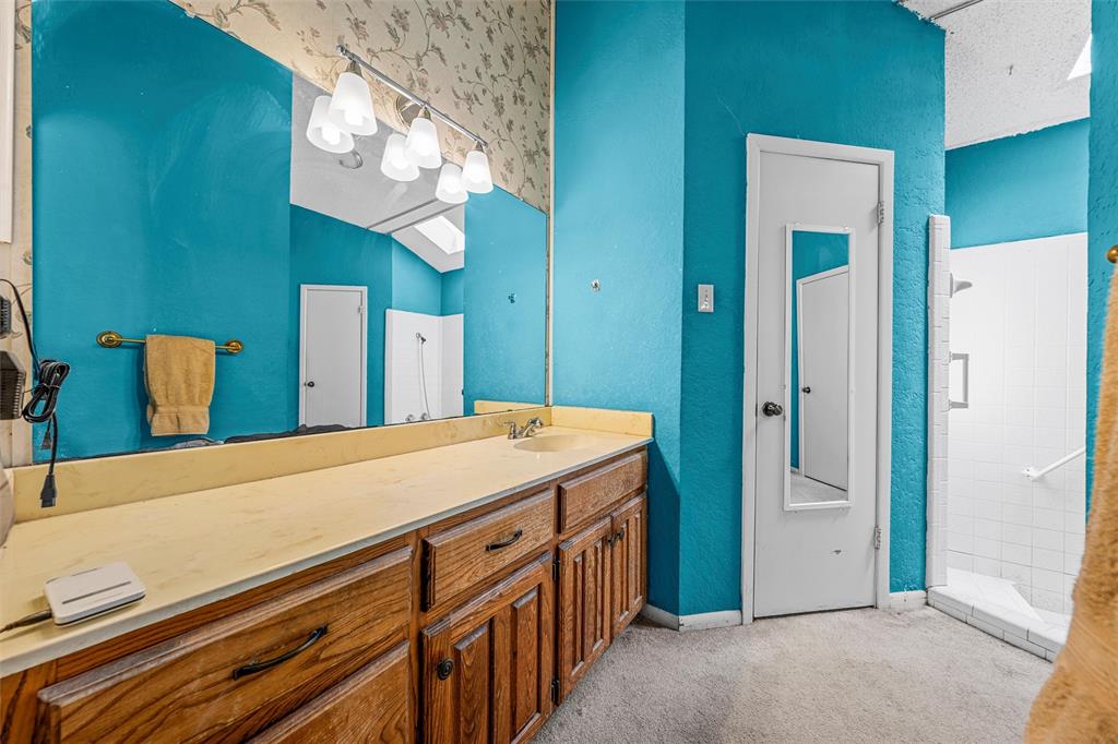 116 Boleman Drive Hewitt, TX 76643 - Photo 28 of 38 Bathroom with vanity, a tile shower, and a textured wall