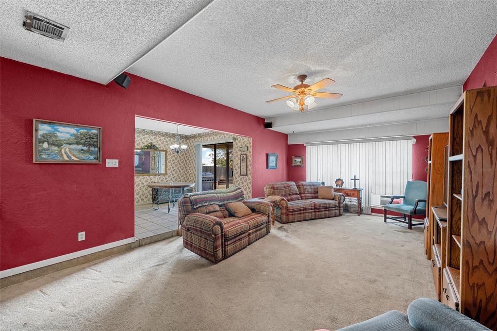 116 Boleman Drive Hewitt, TX 76643 - Photo 5 of 38 Carpeted living room with a textured ceiling, ceiling fan, and a chandelier