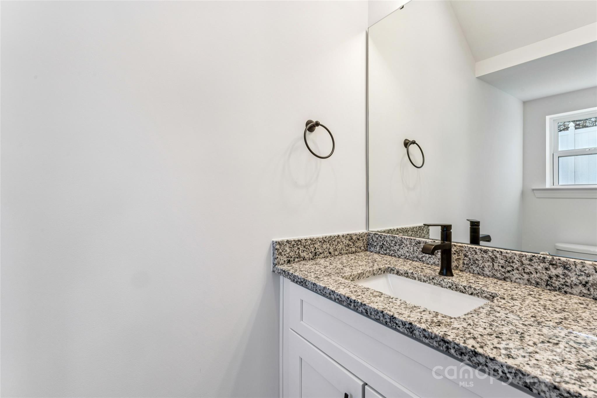 400 South Spargo Street Dallas, NC 28034 - Photo 12 of 26 a bathroom with a granite countertop sink and a mirror