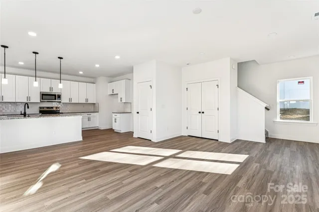 a view of a kitchen with kitchen island a sink stainless steel appliances and cabinets