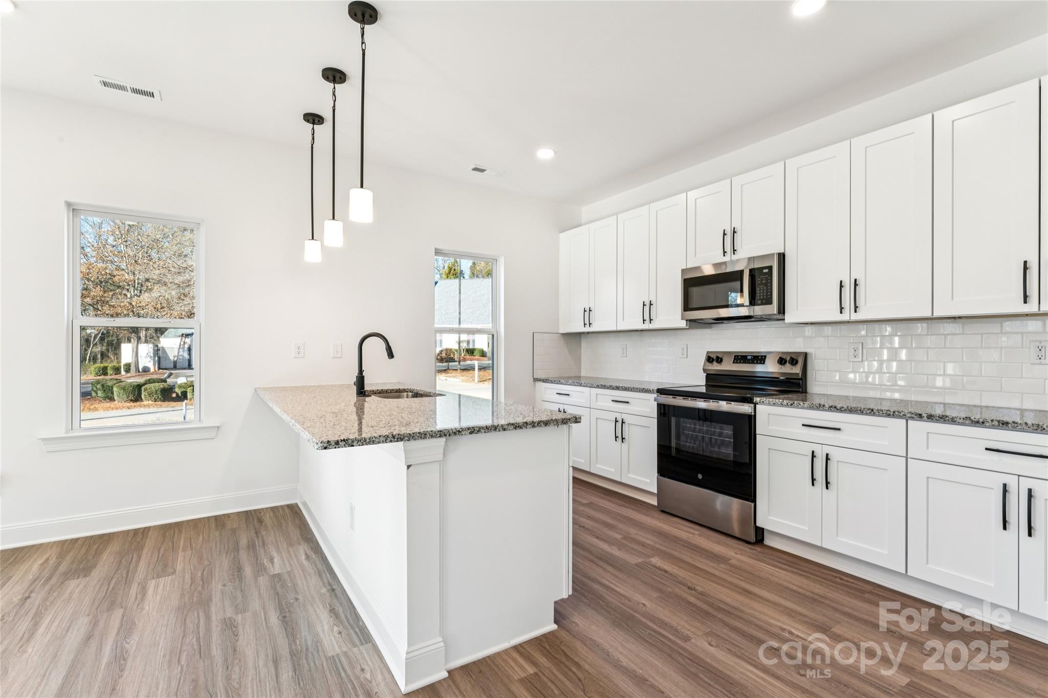 400 South Spargo Street Dallas, NC 28034 - Photo 8 of 26 a kitchen with kitchen island granite countertop a sink cabinets and stainless steel appliances