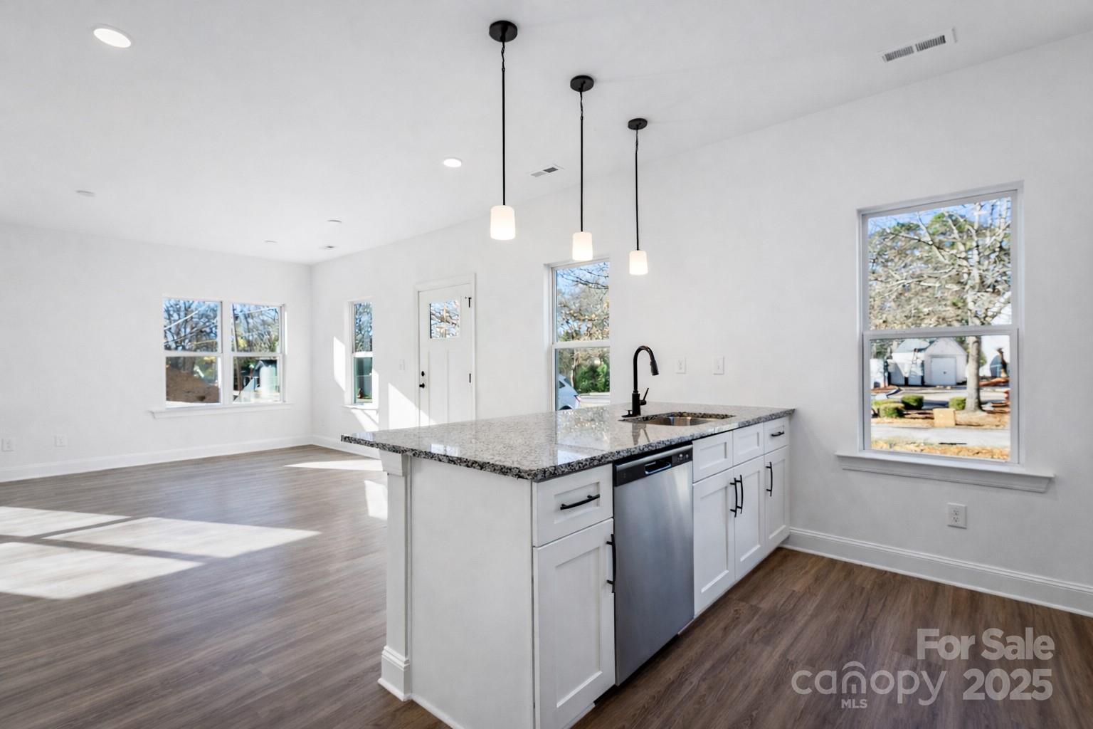 400 South Spargo Street Dallas, NC 28034 - Photo 9 of 26 a kitchen with granite countertop a sink a window and wooden floor
