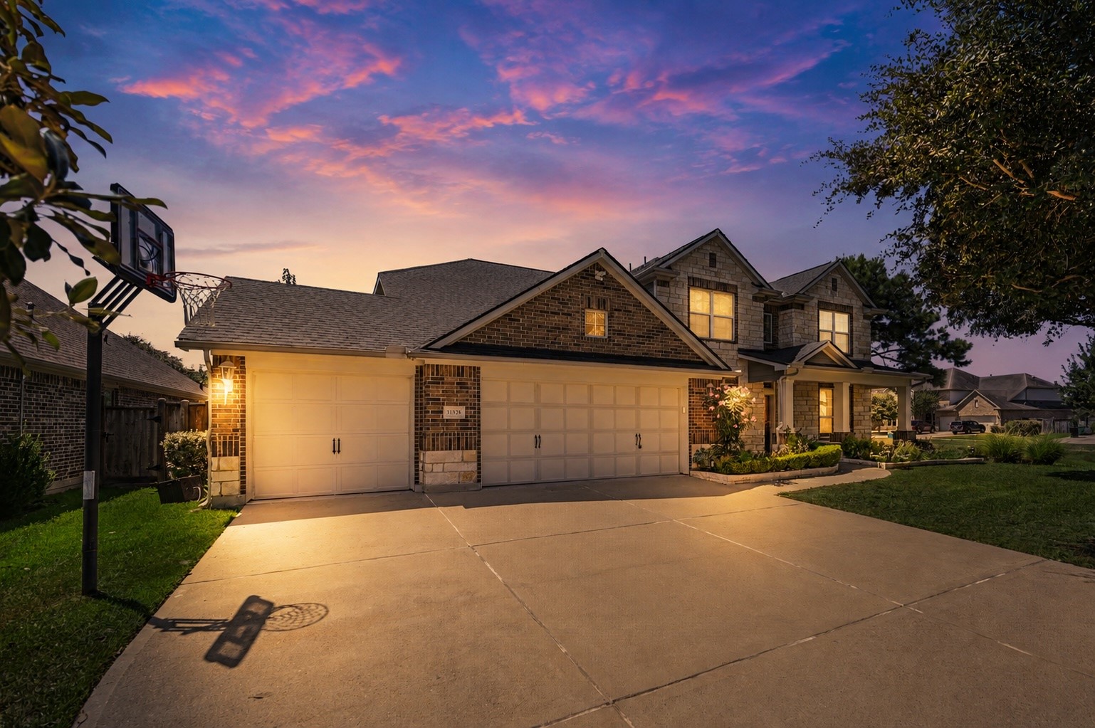 31325 Riley Woods Court Spring, TX 77386 - Photo 2 of 50 Beautiful twilight view showcasing the home’s curb appeal, three car garage and welcoming front entry.