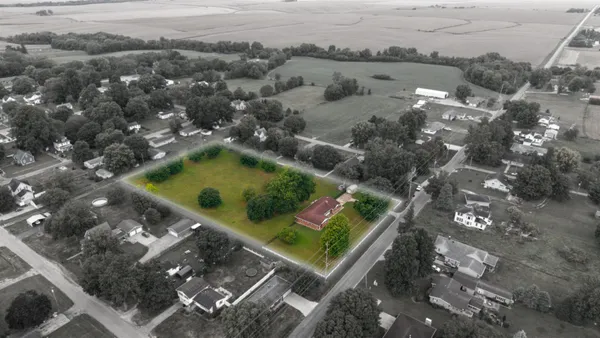 an aerial view of a residential houses with yard
