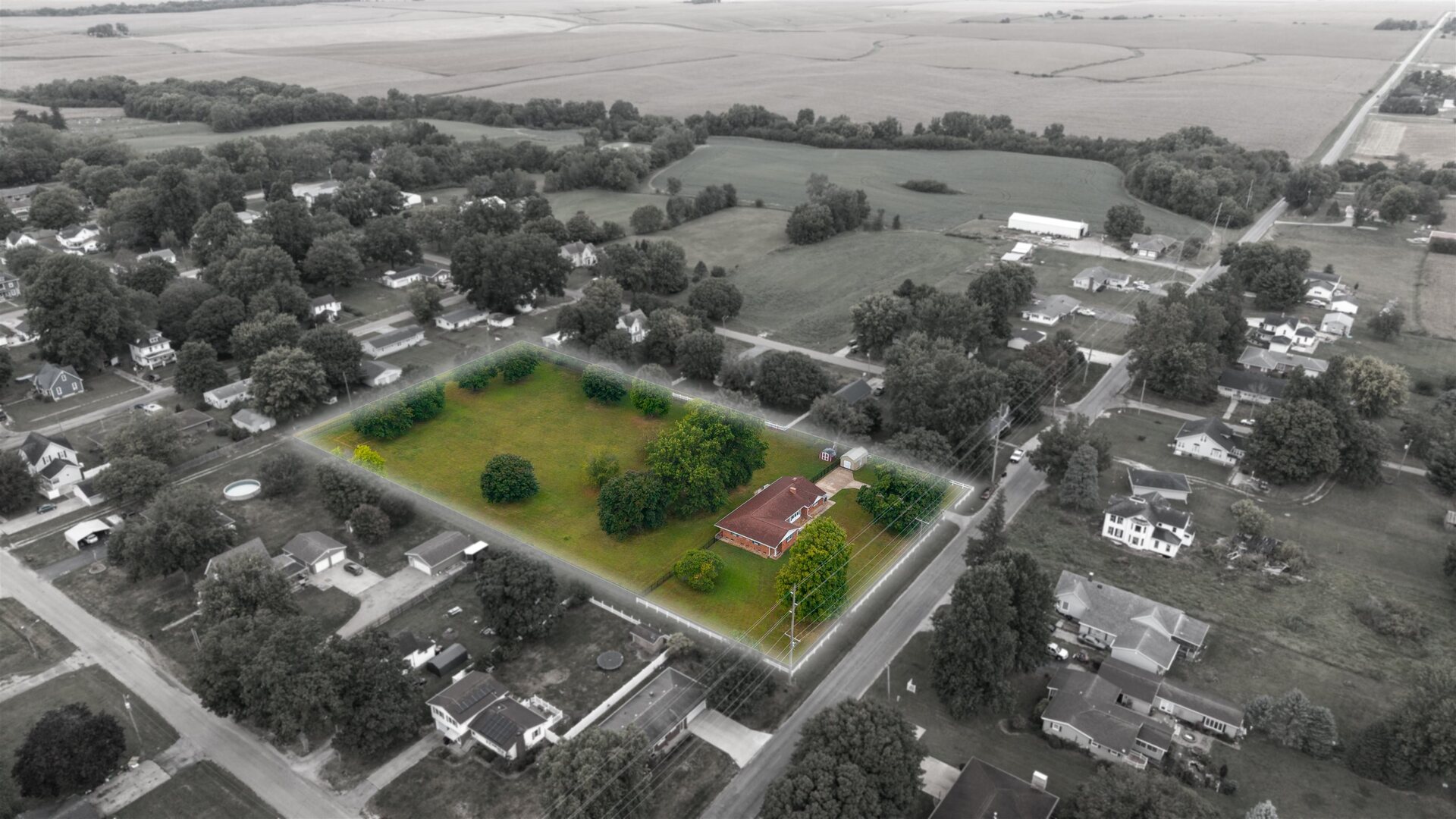 an aerial view of a residential houses with yard