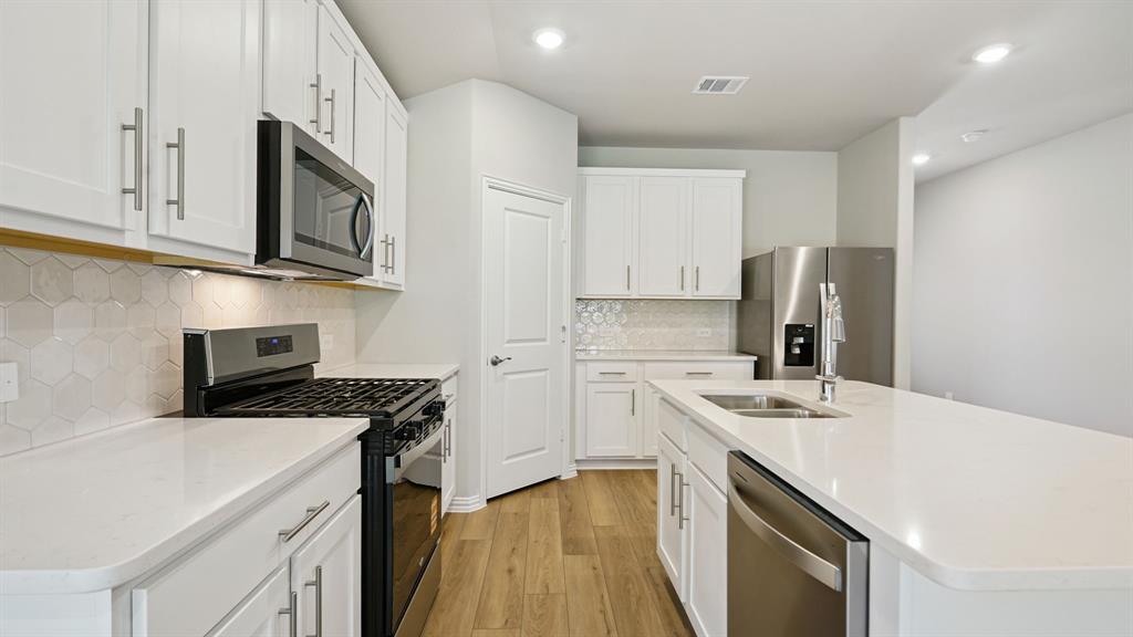 2215 Currents Road Princeton, TX 75407 - Photo 12 of 37 a kitchen with a sink a stove and refrigerator