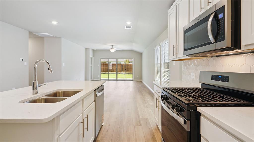 2215 Currents Road Princeton, TX 75407 - Photo 13 of 37 a kitchen that has a sink and a stove