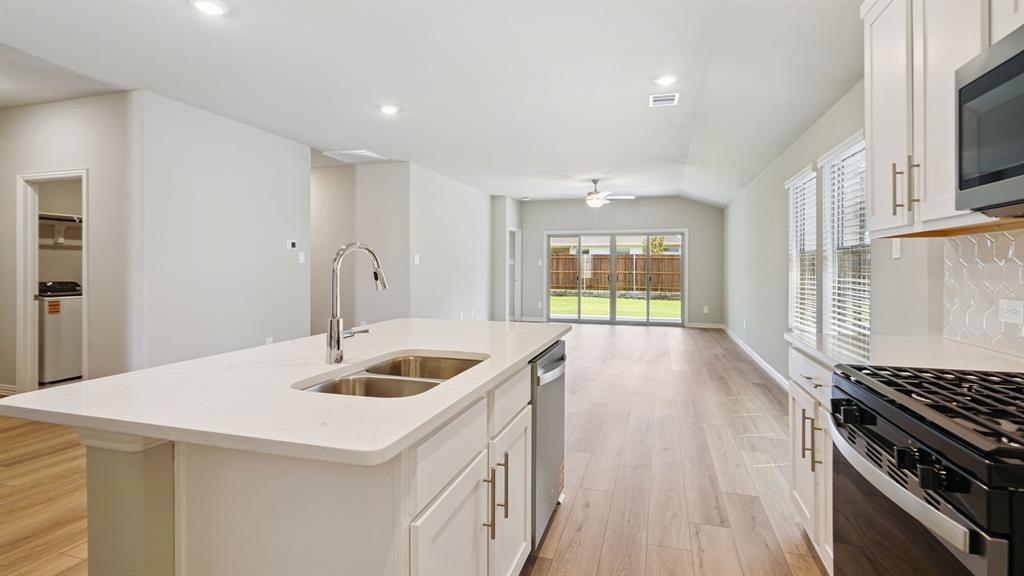 2215 Currents Road Princeton, TX 75407 - Photo 14 of 37 a kitchen that has a sink and a stove