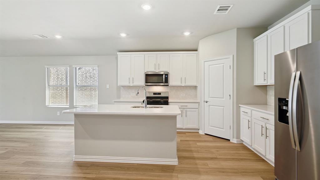 2215 Currents Road Princeton, TX 75407 - Photo 15 of 37 a kitchen with cabinets and stainless steel appliances