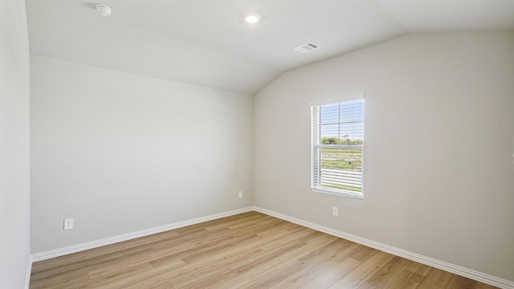 2215 Currents Road Princeton, TX 75407 - Photo 17 of 37 an empty room with wooden floor and windows