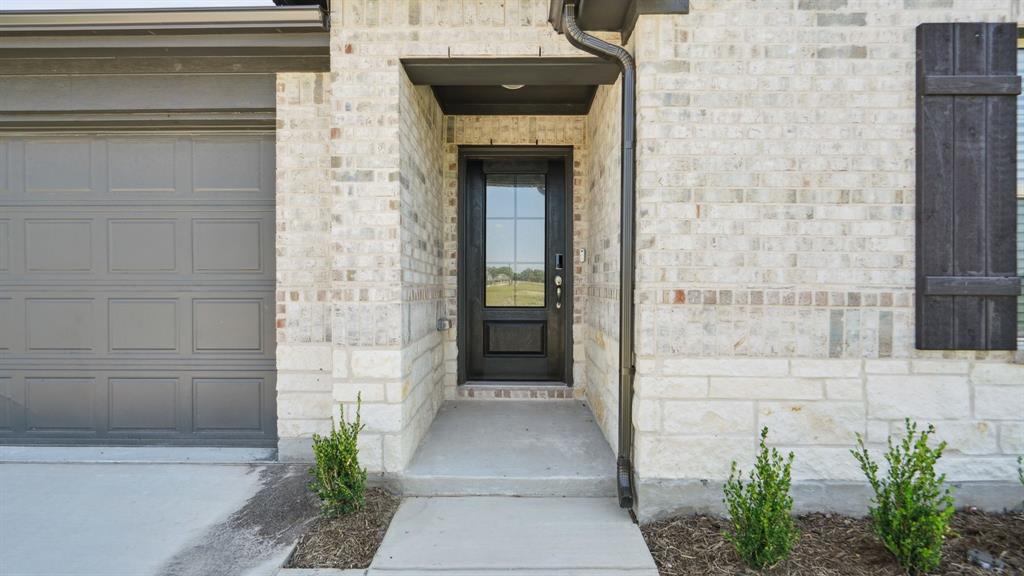 2215 Currents Road Princeton, TX 75407 - Photo 4 of 37 a stone house with potted plants in front of door