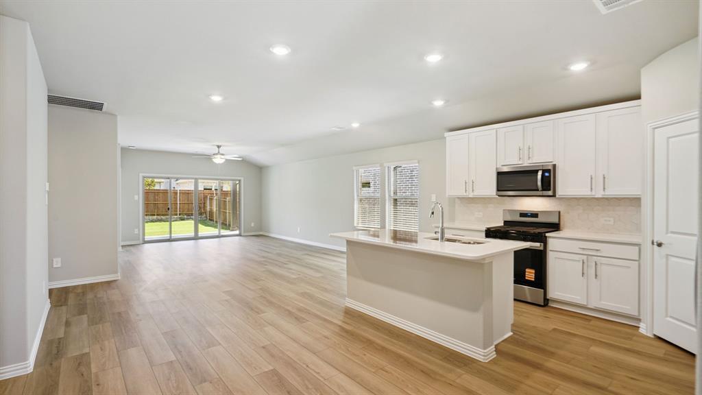 2215 Currents Road Princeton, TX 75407 - Photo 10 of 37 a kitchen with stainless steel appliances granite countertop a stove a sink and a refrigerator