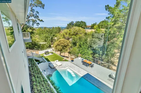 a view of a backyard with couches table and chairs and potted plants