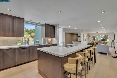a kitchen with stainless steel appliances kitchen island a table chairs sink and refrigerator