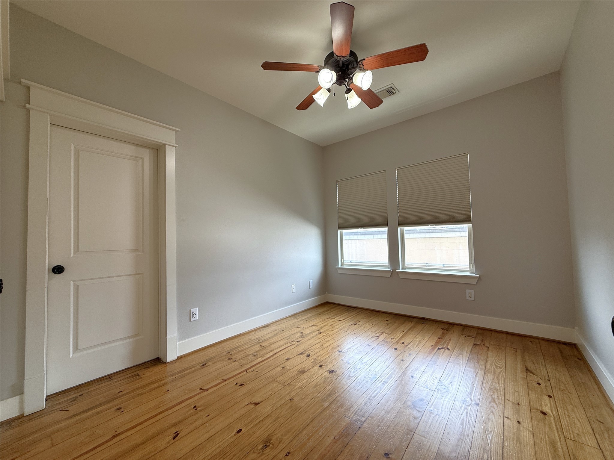 5237 Center Street Houston, TX 77007 - Photo 10 of 27 an empty room with wooden floor chandelier fan and windows