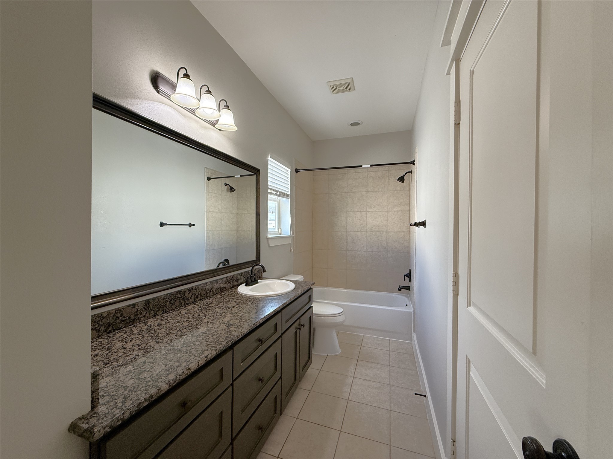 5237 Center Street Houston, TX 77007 - Photo 12 of 27 a bathroom with a granite countertop sink a mirror and a shower