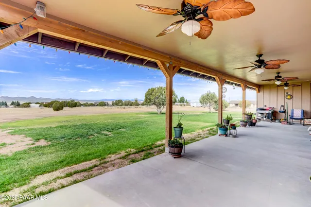 a view of a patio with a table chairs and a backyard
