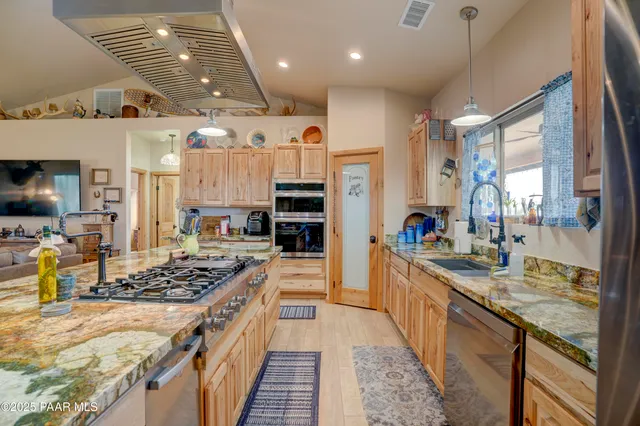 a kitchen with stainless steel appliances kitchen island granite countertop a stove and refrigerator