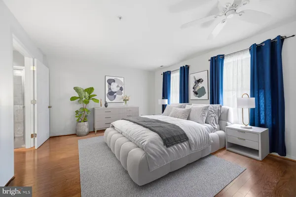 a bedroom with a bed couch and wooden floor