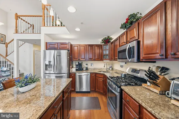 a kitchen with stainless steel appliances granite countertop a stove a sink and a microwave