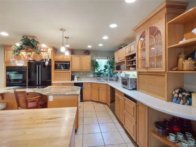 a large kitchen with stainless steel appliances kitchen island granite countertop a sink and cabinets