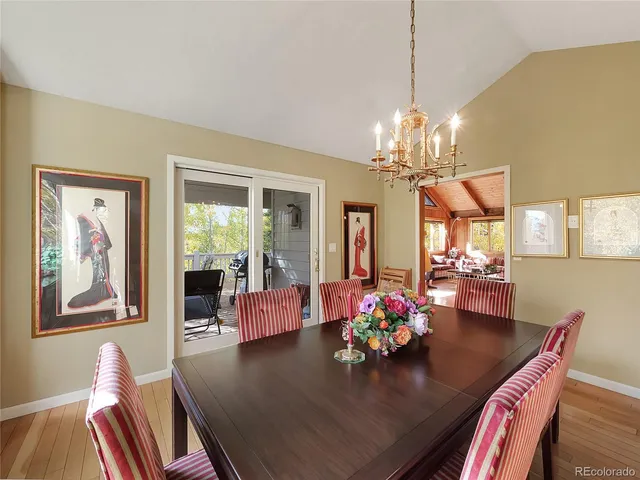 a view of a dining room with furniture a chandelier and wooden floor