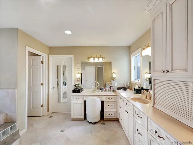 a large white kitchen with a sink and dishwasher a refrigerator with white cabinets