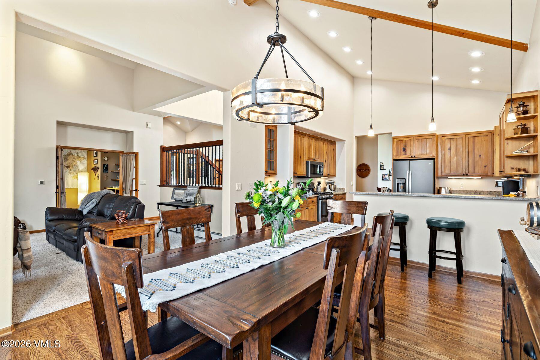 91 Creamery Trail Edwards, CO 81632 - Photo 14 of 44 a dining room with wooden floor a chandelier a glass table and chairs